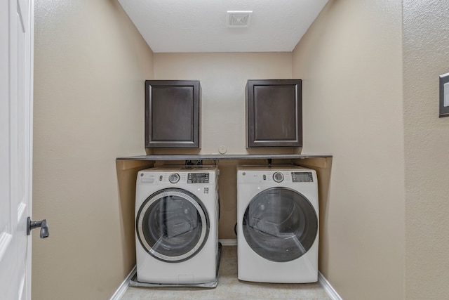 laundry room with baseboards, cabinet space, washer and dryer, and visible vents