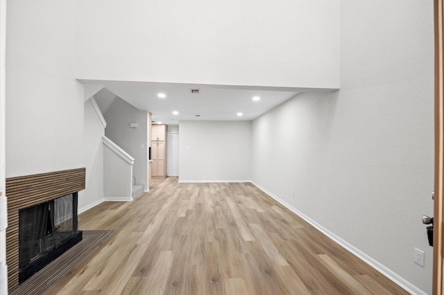 16800 Sugar Pine Dr Unit F51, Houston, TX 77090 - below grade area with baseboards, recessed lighting, a multi sided fireplace, stairs, and light wood finished floors