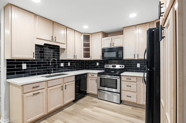 16800 Sugar Pine Dr Unit F51, Houston, TX 77090 - kitchen featuring light brown cabinets, a sink, light countertops, light wood-style floors, and black appliances