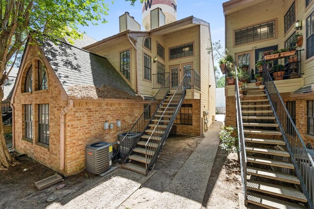16800 Sugar Pine Dr Unit F51, Houston, TX 77090 - back of house featuring cooling unit, a chimney, brick siding, and stairs