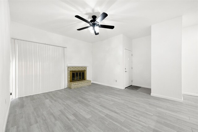 5001 Lamonte Ln Unit 110, Houston, TX 77092 - unfurnished living room featuring baseboards, a ceiling fan, wood finished floors, and a fireplace