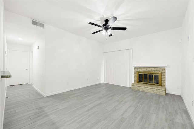 5001 Lamonte Ln Unit 110, Houston, TX 77092 - unfurnished living room with ceiling fan, a brick fireplace, wood finished floors, and visible vents
