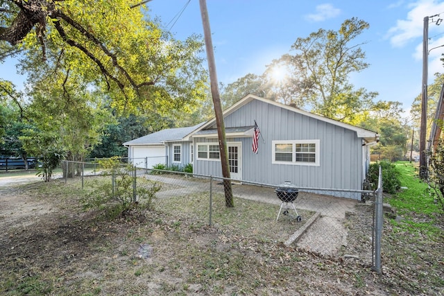 view of front of property featuring board and batten siding, fence private yard, and a garage