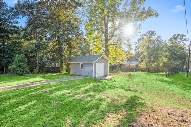 view of yard featuring an outdoor structure and fence