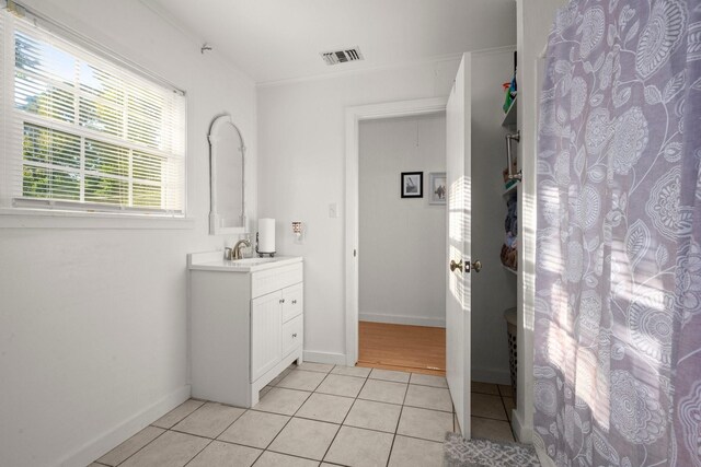 bathroom with visible vents, baseboards, ornamental molding, vanity, and tile patterned flooring