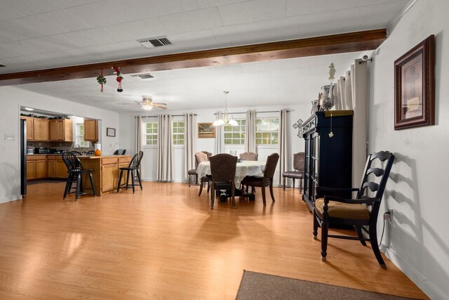 dining room featuring light wood finished floors, baseboards, visible vents, and ceiling fan with notable chandelier