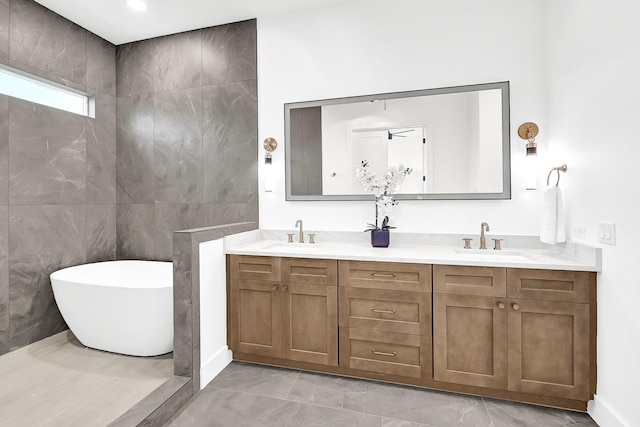 bathroom with double vanity, a sink, a soaking tub, and marble finish floor