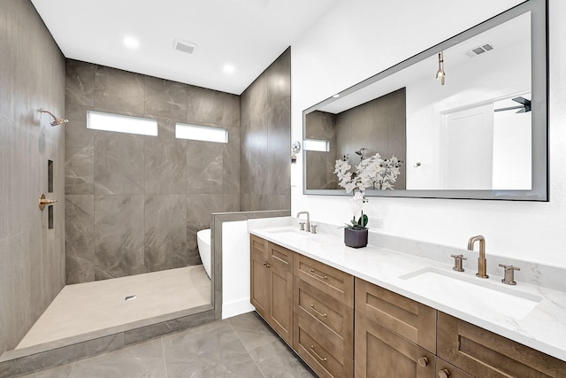 bathroom featuring visible vents, a sink, a tile shower, and double vanity