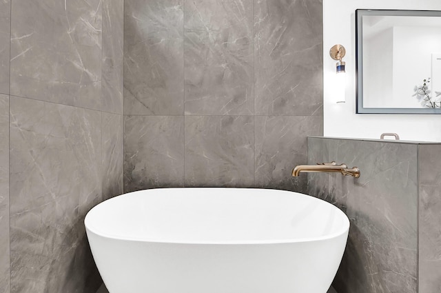 full bathroom with a soaking tub and tile walls
