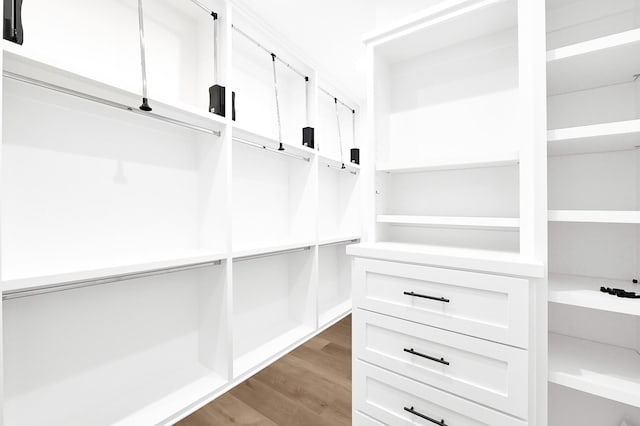 walk in closet with light wood-style flooring