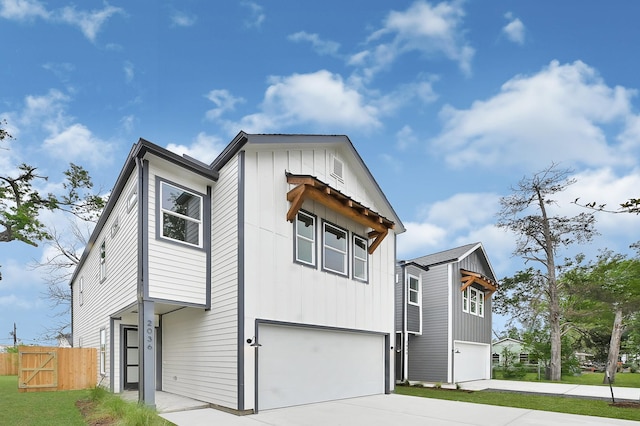 view of front facade with an attached garage, fence, board and batten siding, and concrete driveway
