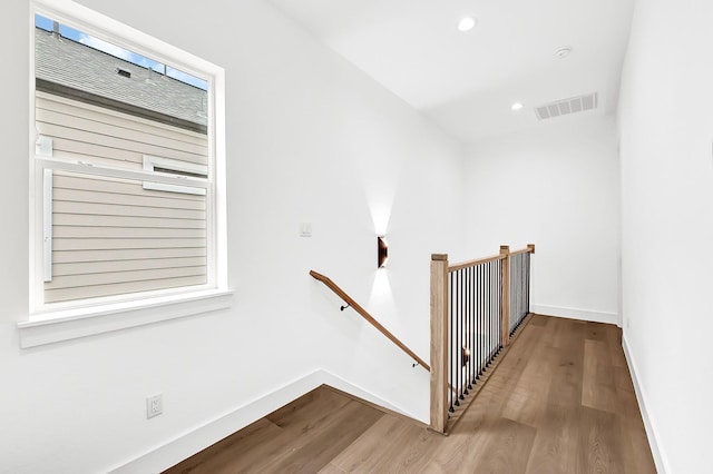 stairs featuring visible vents, plenty of natural light, baseboards, wood finished floors, and recessed lighting