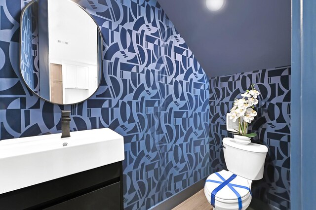 bathroom with visible vents, wallpapered walls, toilet, and vanity