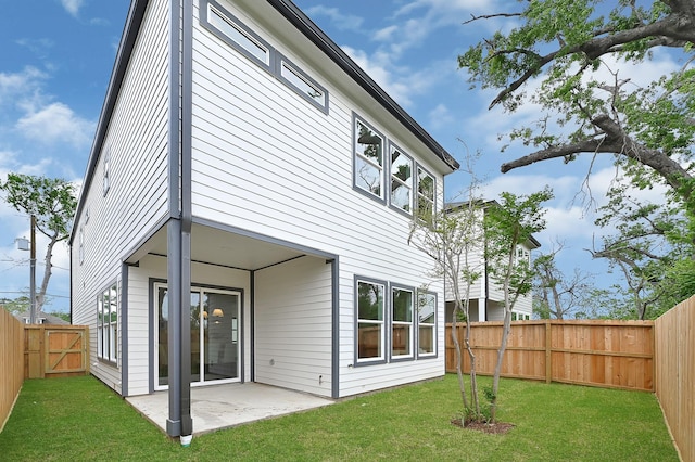 back of property with a fenced backyard, a lawn, a gate, and a patio area