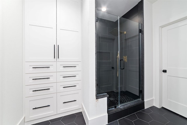 full bathroom featuring a shower stall, baseboards, and tile patterned flooring