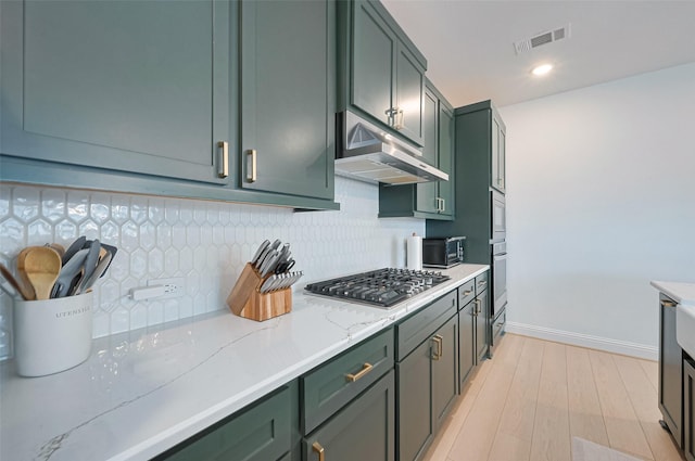 9603 Crescent Mill Dr, Missouri City, TX 77459 - kitchen featuring visible vents, under cabinet range hood, stainless steel gas stovetop, green cabinets, and decorative backsplash