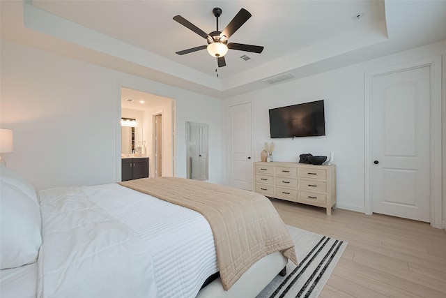 9603 Crescent Mill Dr, Missouri City, TX 77459 - bedroom featuring baseboards, a raised ceiling, ensuite bathroom, ceiling fan, and light wood finished floors