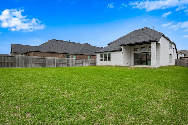 9603 Crescent Mill Dr, Missouri City, TX 77459 - back of property featuring brick siding, a fenced backyard, a lawn, and roof with shingles