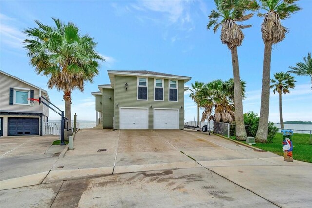 126 Tamana Dr, Tiki Island, TX 77554 - view of front of property with a gate, driveway, a garage, and fence