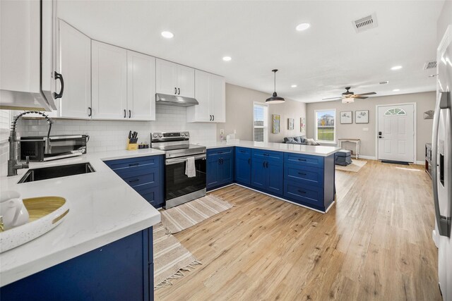2008 71st St, Galveston, TX 77551 - kitchen with electric stove, a sink, blue cabinets, under cabinet range hood, and a peninsula