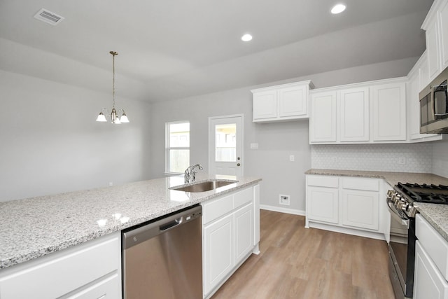 kitchen with white cabinets, visible vents, light wood-style flooring, appliances with stainless steel finishes, and a sink