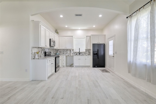 49 Regency Pt, Conroe, TX 77356 - kitchen featuring stainless steel appliances, backsplash, a sink, visible vents, and white cabinets
