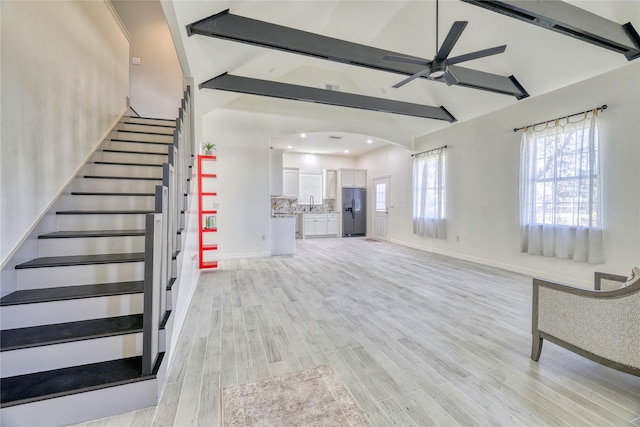 49 Regency Pt, Conroe, TX 77356 - unfurnished living room with beamed ceiling, a wealth of natural light, light wood-style floors, and a ceiling fan