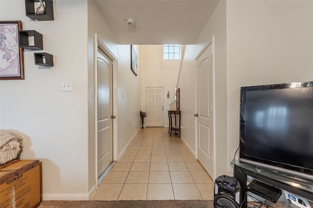 hallway with light tile patterned flooring and baseboards