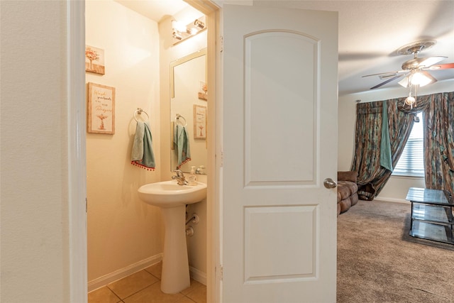 bathroom featuring tile patterned floors, a sink, baseboards, and ceiling fan