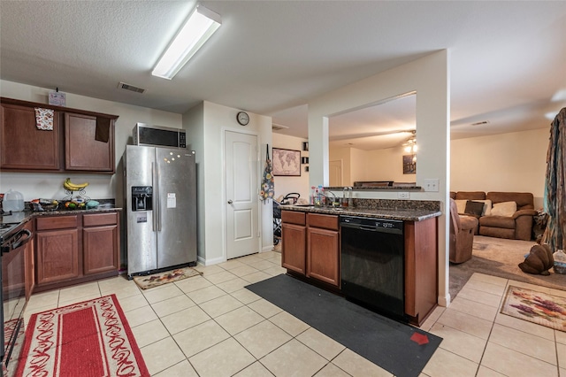 kitchen featuring visible vents, black appliances, dark stone countertops, and light tile patterned floors