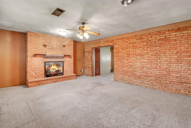 2509 Bayou Ave, Baytown, TX 77520 - unfurnished living room featuring carpet flooring, a ceiling fan, a brick fireplace, and brick wall