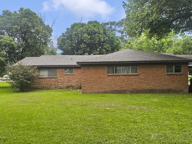 2509 Bayou Ave, Baytown, TX 77520 - view of side of property featuring a yard, brick siding, and roof with shingles