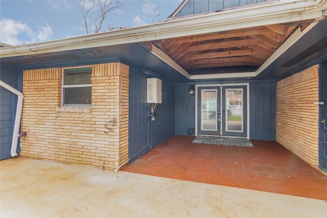 entrance to property featuring french doors and brick siding