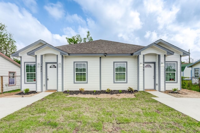 single story home with fence, a front lawn, and roof with shingles