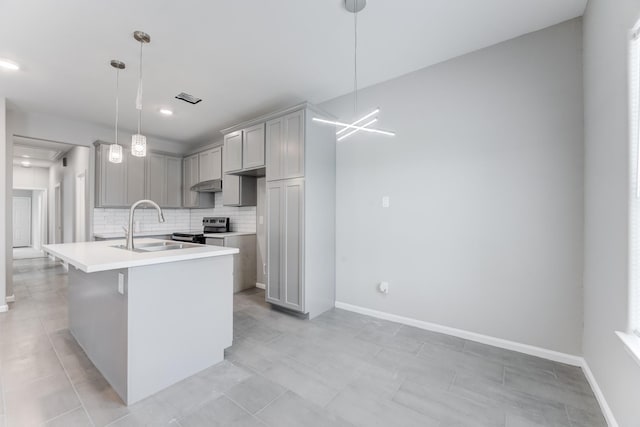 kitchen with light countertops, a sink, gray cabinetry, backsplash, and stainless steel electric stove
