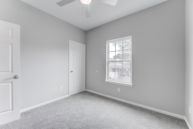 spare room featuring a ceiling fan, carpet, and baseboards