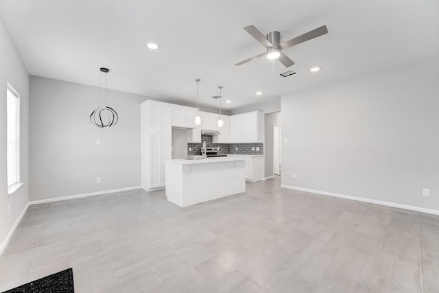 kitchen with open floor plan, light countertops, stainless steel electric range, decorative backsplash, and a ceiling fan