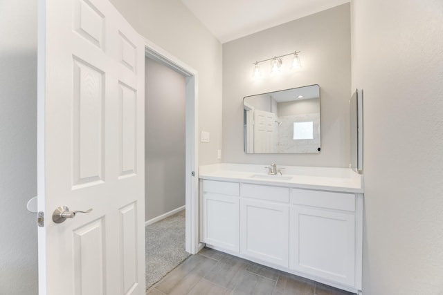 full bathroom with baseboards, a shower, and vanity