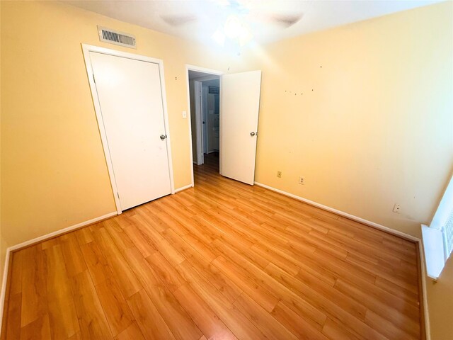 unfurnished bedroom featuring baseboards, light wood finished floors, and visible vents
