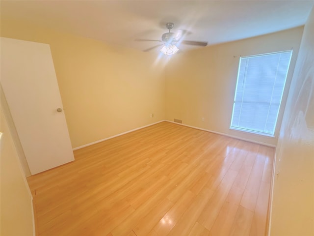 unfurnished room featuring baseboards, ceiling fan, visible vents, and light wood-type flooring