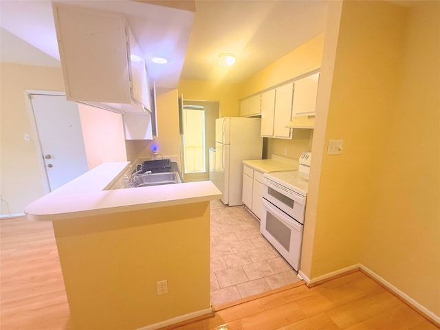 kitchen with light countertops, a sink, a peninsula, white appliances, and white cabinets