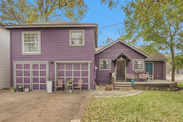 traditional-style home with concrete driveway, a garage, and a front lawn