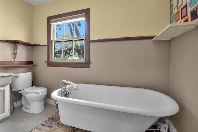 full bathroom featuring baseboards, a freestanding bath, and toilet