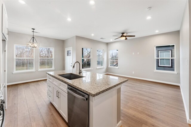 kitchen featuring a sink, light wood-style floors, dishwasher, baseboards, and white cabinetry