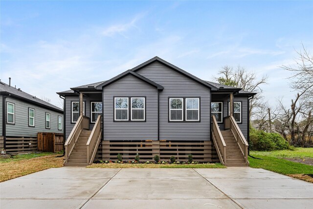 view of front of property featuring fence and stairs