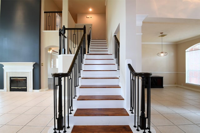 18719 Racquet Sports Way, Humble, TX 77346 - staircase with tile patterned flooring, crown molding, baseboards, and a fireplace
