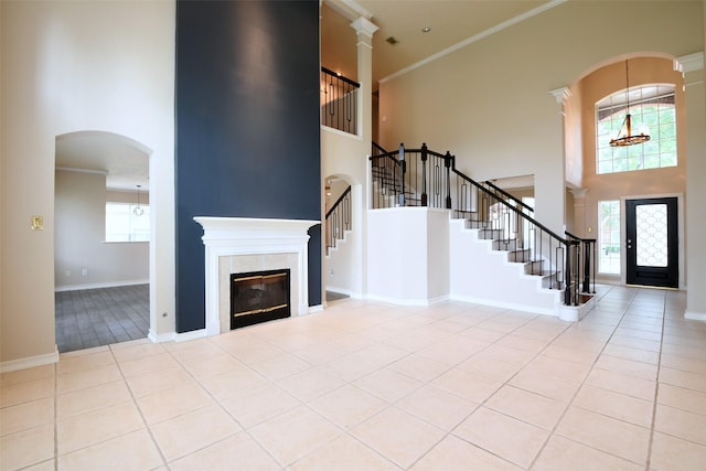 18719 Racquet Sports Way, Humble, TX 77346 - entrance foyer featuring a high ceiling, stairs, ornamental molding, light tile patterned floors, and a tiled fireplace