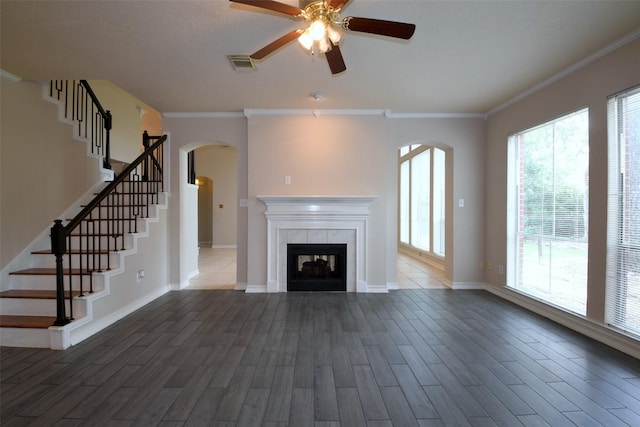 18719 Racquet Sports Way, Humble, TX 77346 - unfurnished living room with arched walkways, a ceiling fan, stairs, wood finished floors, and ornamental molding