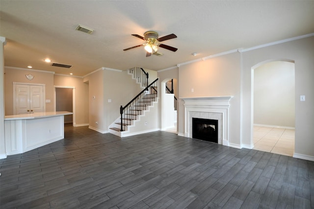 18719 Racquet Sports Way, Humble, TX 77346 - unfurnished living room featuring a ceiling fan, ornamental molding, arched walkways, a tile fireplace, and baseboards