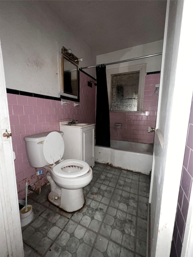 bathroom with tile walls, toilet, tile patterned floors, vanity, and bathing tub / shower combination